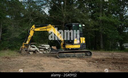 Yellow yanmar Bagger Abriss alten Ziegelkamin viel zu löschen Stockfoto