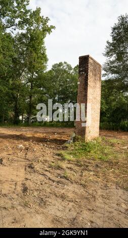 Yellow yanmar Bagger Abriss alten Ziegelkamin viel zu löschen Stockfoto