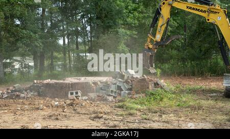 Yellow yanmar Bagger Abriss alten Ziegelkamin viel zu löschen Stockfoto