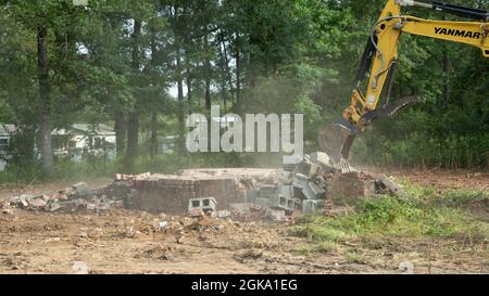 Yellow yanmar Bagger Abriss alten Ziegelkamin viel zu löschen Stockfoto