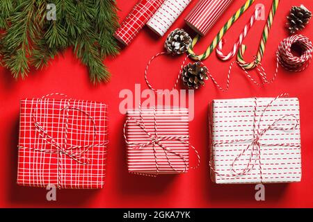 Drei Weihnachtsgeschenke auf rotem Hintergrund. Feier und Geschenkverpackung. Stockfoto