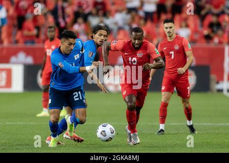 Toronto, Kanada, 8. September 2021: Junior Hoilett, Platz 10, vom Team Canada im Einsatz gegen zwei Spieler des Team El Salvador, Bryan Tamacas (Platz 21) und Enrico Hernández (Platz 20) während des CONCACAF World Cup Qualifying 2022-Spiels auf dem BMO-Feld in Toronto, Kanada. Kanada gewann das Spiel mit 3:0. Stockfoto