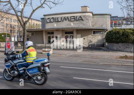 Columbia Theatre auf dem Airlift Square mit vorbeifahrenden Polizeimotorrädern Stockfoto