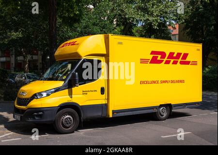 Seitenansicht von vorne rechts eines DHL-Transporters, der am Straßenrand steht Stockfoto