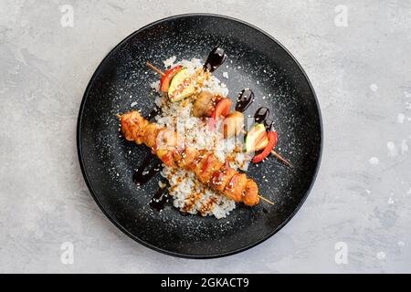 Blick von oben auf Schaschlik mit Huhn und gegrilltem Champignon mit Paprika und Zucchini serviert mit gekochtem Reis Stockfoto