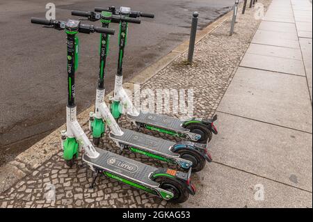 Eine Reihe von drei stehenden Elektro-scooter oder E-Scooter der Firma KALK auf dem Bürgersteig in Berlin Stockfoto
