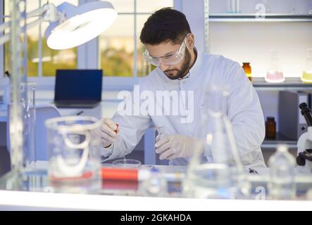 Männlicher Wissenschaftler, der im wissenschaftlichen Labor mit Chemikalien arbeitet Stockfoto