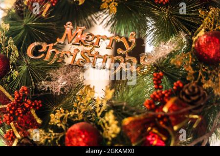 Nahaufnahme eines bunten Weihnachtskranzes aus Piniennadeln, Zapfen und Ornamenten Stockfoto