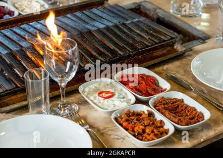 Verschiedene Arten von Fleisch gegrillt auf dem Grill auf dem Tisch, serviert mit speziellen türkischen Vorspeisen und türkischen Raki. Stockfoto