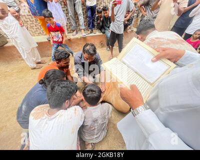 Einige Menschen schneiden ein Kuhopfer auf dem Fest von Eid-ul-Adha Stockfoto