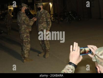 Der Kommandokaplan des 33. Sustainment Command (Expeditionary) der Army Reserve, Maj. David Beetham, steht kurz vor Brig zur Aufmerksamkeit. General Justin Swanson, der 33. General des ESC, nimmt ihn bei einer informellen Promotionszeremonie am 1. März 2021 im Camp Arifjan, Kuwait, in den Rang eines LT. Col. Ein. Neben seinen Kollegen bei der Zeremonie beobachteten Beethams Frau und Kinder die Aktion im Livestream. Brig. General Justin Stockfoto