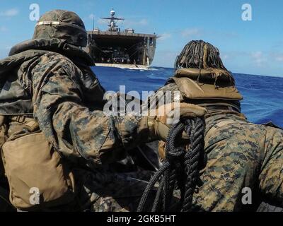 U.S. Marines mit dem Bataillon Landing Team, 3. Bataillon, 4. Marines, 31. Marine Expeditionary Unit (MEU), bereiten sich vor, nach einem Bootsstart in der Nähe von Peleliu in der philippinischen See, am 1. März 2021, das Hecktor des Anlegedocks USS Ashland (LSD 48) zu betreten. Die 31. MEU ist an Bord der Schiffe der Amphibiengeschwader 11 im Einsatzgebiet der 7. Flotte tätig, um die Interoperabilität mit Verbündeten und Partnern zu verbessern und als einsatzbereite Einsatztruppe zur Verteidigung von Frieden und Stabilität in der Indopazifik-Region zu dienen. Stockfoto