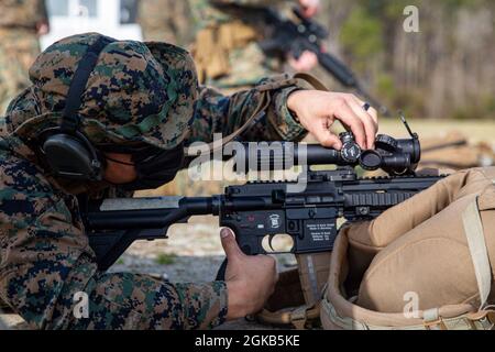 U.S. Marine Corps Sgt. Matthew Adams, ein Instruktor der School of Infantry-East, passt seine Reichweite an, bevor er sein M27-Infanterie-Sturmgewehr während des 2021 Marine Corps Base Camp Lejeune Intramgewehr- und Pistolenwettbewerbs abfeuerte, der am 1. März 2021 auf der Alpha Range in Stone Bay, North Carolina, stattfand. Der Wettbewerb besteht aus einem zweiwöchigen Qualifikationskurs für Gewehr und Pistole, der die Fähigkeiten der Marines im Bereich der Kampfkünste hervorheben soll. Stockfoto