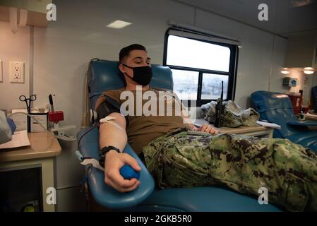 Der Hospitalist Kendall Lyles, ein Seemann, der an Bord der Naval Health Clinic Cherry Point dient, spendet am Montag, den 1. März 2021, während einer Blutverbringung durch das Armed Services Blood Program. Das vom Armed Services Blood Program an Bord der Marine Combat Aviation Station Cherry Point veranstaltete Programm sammelte über 28 Pints Blut. Stockfoto