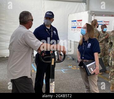 Miami, FL, (1. März 2021) -Region 4 Regionaladministrator Gracia B. Szczech, rechts, spricht mit Partnern des Impfzentrums, das am Miami Dade Community College eingerichtet wird. Die FEMA und die Partner des Verteidigungsministeriums arbeiten mit dem Staat zusammen, um das Zentrum für eine Eröffnung am 3. März 2021 zu errichten. Stockfoto