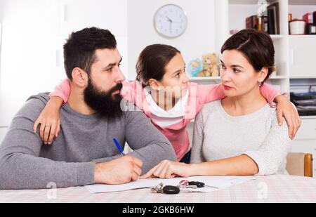 Eltern unterzeichnen Papiere für Scheidung Stockfoto