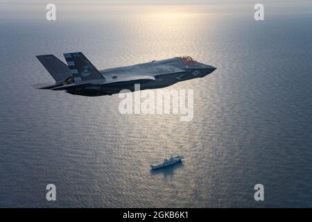 Marine Corps Maj. Brad „HJOP“ Leeman, Air Test and Evaluation Squadron (VX) 23, hält eine italienische Flagge, während er einen von zwei F-35B von der Naval Air Station Patuxent River, Maryland, zum italienischen Flugzeugträger ITS Cavour (CVH 550), am 1. März 2021 fliegt. Leeman und Royal Navy LT. Cmdr. Barry „Baz“ Pilkington, VX-23, führte das Anfliegen der beiden F-35B-Varianten durch, die von der F-35 Pax River Integrated Test Force und Mitarbeitern der italienischen Marine für die F-35B Sea Trials an Bord des Carriers verwendet wurden. Der Flugtest des F‐35B Lightning II an Bord DES Cavour ist ein wichtiger Meilenstein auf dem Weg zur Qualifikation der italienischen Fluggesellschaft Stockfoto