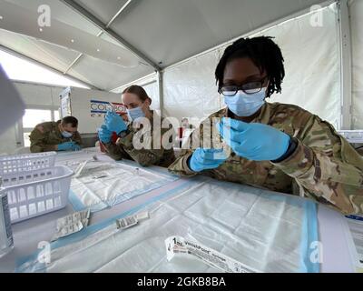 Miami, FL (2. März 2021) – Soldaten, die ein Miami-Dade Community Vaccine Center unterstützen, füllen Spritzen mit COVID-19-Impfungen, damit sich die Gemeinschaft daran erinnert, den Impfstoff erhalten zu haben. Stockfoto