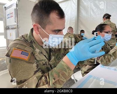 Miami, FL (2. März 2021) – Soldaten, die ein Miami-Dade Community Vaccine Center unterstützen, füllen Spritzen mit COVID-19-Impfungen, damit sich die Gemeinschaft daran erinnert, den Impfstoff erhalten zu haben. Stockfoto