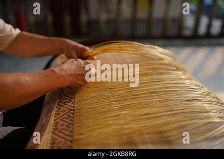 (210914) -- XINYU, 14. September 2021 (Xinhua) -- Li Nian'gen stellt Bambuswebprodukte in der Gemeinde Dongcun, Bezirk Fenyi, Stadt Xinyu in der ostchinesischen Provinz Jiangxi, her, 1. September 2021. Li Nian'gen, 62, ist die fünfte Generation der Bambuswebtechniken in der Gemeinde Dongcun. Li erwarb Bambuswebtechniken von seinem Onkel, als er gerade einmal neun Jahre alt war, und begann mit 15 Jahren, seinen Lebensunterhalt allein zu verdienen. Mehr als 20 seiner Lehrlinge entschieden sich Anfang der 1990er Jahre, in anderen Lebensbereichen außerhalb seiner Heimat eine Beschäftigung für besseres Einkommen zu suchen, aber Li beschloss, zu bleiben und sich an seine p zu halten Stockfoto