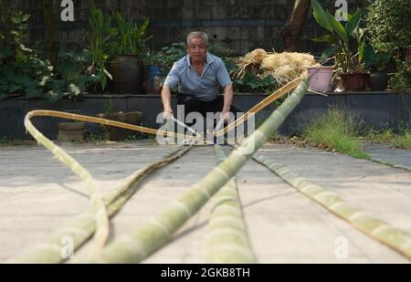 (210914) -- XINYU, 14. September 2021 (Xinhua) -- Li Nian'gen bereitet Rohstoffe für seine Bambusprodukte in der Gemeinde Dongcun, Bezirk Fenyi, Stadt Xinyu in der ostchinesischen Provinz Jiangxi, am 2. September 2021 vor. Li Nian'gen, 62, ist die fünfte Generation der Bambuswebtechniken in der Gemeinde Dongcun. Li erwarb Bambuswebtechniken von seinem Onkel, als er gerade einmal neun Jahre alt war, und begann mit 15 Jahren, seinen Lebensunterhalt allein zu verdienen. Mehr als 20 seiner Lehrlinge entschieden sich Anfang der 1990er Jahre für eine Beschäftigung für besseres Einkommen in anderen Lebensbereichen außerhalb seiner Heimat, aber Li entschied sich, eine zu bleiben Stockfoto