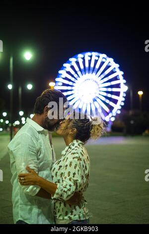 Liebevolles Paar umarmt und küsst sich auf der Straße in der Nacht. Paar romantizieren und verbringen eine gute Zeit im Freien. Liebevolles Paar küsst wi Stockfoto
