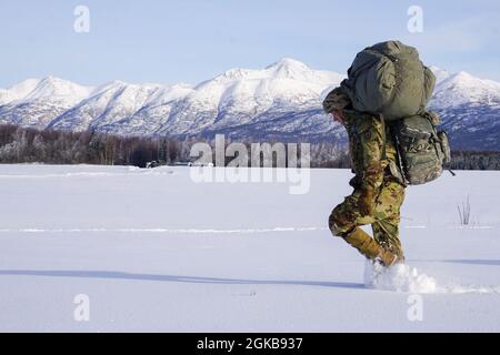 Ein Fallschirmjäger des 1. Bataillons, des 501. Fallschirmjägerregiments, des 4. Kampfteams der Infanterie-Brigade (Airborne), der 25. Infanterie-Division, der „Spartan Brigade“, zieht während einer Luftoperation in die Malemute Drop Zone, Joint Base Elmendorf-Richardson, Alaska, am 2. März 2021, in den Sammelbereich. Die Spartan Brigade ist das einzige Kampfteam der luftgestützten Infanteriebrigade in den arktischen und pazifischen Theatern und bietet dem Kampfkommandanten die einzigartige Fähigkeit, eine Expeditionstruppe aus der Luft zu projizieren. Stockfoto