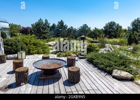 Outdoor-Sitzbereich mit Grill und Holzstümpfe im Hinterhof des Landguts im Sommer Stockfoto