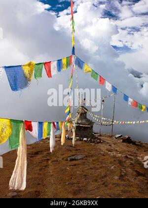 Blick von Langtang nach Ganesh Himal mit Stupa und Gebetsfahnen und schönen Wolken - Nepal Stockfoto