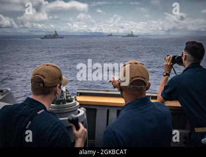 Lt. Bef. Gerald Sellars gibt ENS Anweisungen. James Bateman auf der Brücke des Arleigh Burke-Klasse Lenkraketen-Zerstörers USS John S. McCain (DDG 56) während der Teilnahme an einer Gruppenmanöver-Übung mit Schiffen, die Destroyer Squadron (DESRON) 15 und der Japan Maritime Self-Defense Force (JMSDF) während der jährlichen US-Japan bilateral Advanced Warfighting Training Übung zugewiesen wurden. BAWT konzentriert sich auf die gemeinsame Ausbildung und Interoperabilität von Koalitionskräften und ermöglicht die Ermöglichung von Kompetenz und Bereitschaft in der realen Welt als Reaktion auf alle Eventualitäten. Stockfoto