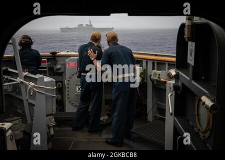 Lt. Bef. Gerald Sellars gibt ENS Anweisungen. James Bateman auf der Brücke des Arleigh Burke-Klasse Lenkraketen-Zerstörers USS John S. McCain (DDG 56) während der Teilnahme an einer Gruppenmanöver-Übung mit Schiffen, die Destroyer Squadron (DESRON) 15 und der Japan Maritime Self-Defense Force (JMSDF) während der jährlichen US-Japan bilateral Advanced Warfighting Training Übung zugewiesen wurden. BAWT konzentriert sich auf die gemeinsame Ausbildung und Interoperabilität von Koalitionskräften und ermöglicht die Ermöglichung von Kompetenz und Bereitschaft in der realen Welt als Reaktion auf alle Eventualitäten. Stockfoto