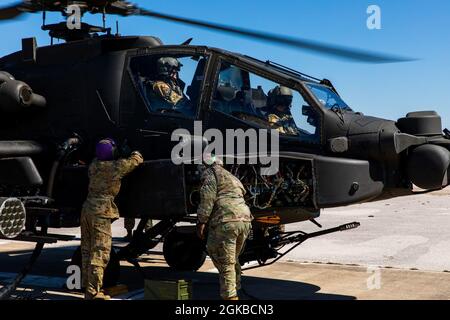 Soldaten der Bravo-Truppe, der 7. Staffel, des 17. Kavallerieregiments, der 1. Kavalleriedivision beenden am 3. Februar 2021 das Tanken und Laden von Patronen auf einen Apache AH-64E in Fort Hood, Texas. Die AH-64E trägt mehrere Waffensysteme, darunter die hier abgebildete M230 Chain Gun, die für eine 30 mm Runde gekammert ist. Stockfoto