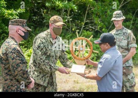 US Marine Corps Col. Michael Nakonieczny, 31. Kommandant der Marine Expeditionary Unit (MEU), Und der US-Navy-Kapitän Brian Schrum, Kommandant der USS New Orleans (LPD 18), überreichen dem Gouverneur Temmy Shmall, Gouverneur des Staates Peleliu, zusammen mit dem US-Armeemajor Matthew See von der Task Force Oceania auf der Insel Peleliu in der Republik Palau ein Geschenk, 3. März 2021. Die 31. MEU ist an Bord von Schiffen der Amphibiengeschwader 11 im Einsatzgebiet der 7. Flotte tätig, um die Interoperabilität mit Verbündeten und Partnern zu verbessern und als einsatzbereite Einsatztruppe für Frieden und Stabilität in zu dienen Stockfoto