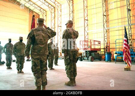 Col. Mark Coble und Sgt. Maj. John Shannon, 734. Regionale Unterstützungsgruppe, grüßt die Farben der Einheit, nachdem sie während der Zeremonie zur Übertragung der Autorität auf der Al Asad Air Base, Irak, am 3. März 2021 entfärbt wurden. Die Einheit der Iowa National Guard wird Funktionen von Basisunterstützungsintegratoren und Basislager-Diensten zur Unterstützung der operationsinhärenten Lösung übernehmen. Stockfoto