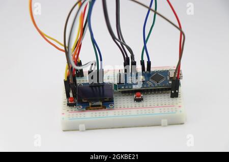 Die Breadboard-Schaltung aus Displaymodul und Mikrocontrollerplatine, die mit Drähten verbunden ist, zeigt das Konzept innovativer STEM-Projekte, OLED-Display pro Stockfoto