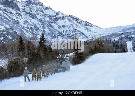 Soldaten des 1. Bataillons, 501st Fallschirmjäger-Regiment skijour hinter einem kleinen Einheiten-Unterstützungsfahrzeug als Teil der United States Army Alaska Winter Games 4. März 2021 auf dem Black Rapids Training Site. Als amerikanische Arctic Warriors und die US-Armee-Experten für das Überleben, den Betrieb, den Kampf und den Sieg in extrem kalten Wetter- und Höhenlagen sind alle während der Spiele getesteten Fähigkeiten für die Fähigkeiten des USARAK Soldier von entscheidender Bedeutung. Diese Spiele bestätigen die Expertise der Soldaten und setzen einen Maßstab für Exzellenz für alle Arktischen Krieger. (Foto der Armee/John Pennell) Stockfoto