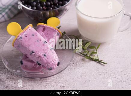 Hausgemachtes Excimo-Eis mit Beeren auf einem transparenten Teller schmelzen. Stockfoto
