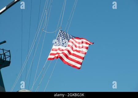 210304-N-RG171-0244 MITTELMEER (MÄRZ 4, 2021) der Arleigh Burke-Klasse Lenkraketen-Zerstörer USS Donald Cook (DDG 75) fliegt das nationale Fähnchen während einer Beerdigung auf See, 4. März 2021. Donald Cook, der im spanischen Rota stationiert ist, ist auf Patrouille im Einsatzgebiet der Sechsten Flotte der USA, um regionale Verbündete und Partner sowie die nationale Sicherheit der USA in Europa und Afrika zu unterstützen. Stockfoto