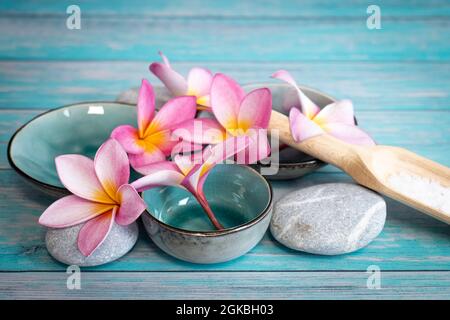 frangipani blüht als Spa-Konzept mit Zen-Steinen und kleinen Schalen Stockfoto