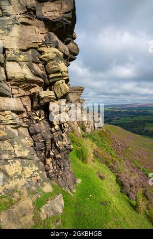 The Worm Stones, ein Grabstein in den Hügeln oberhalb von Glossop am High Peak, Derbyshire, England. Heidekraut blüht auf den Mooren unten. Stockfoto