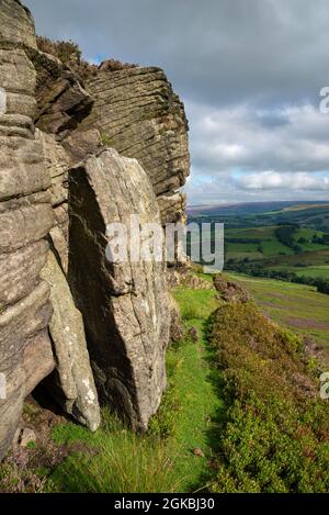 The Worm Stones, ein Grabstein in den Hügeln oberhalb von Glossop am High Peak, Derbyshire, England. Heidekraut blüht auf den Mooren unten. Stockfoto