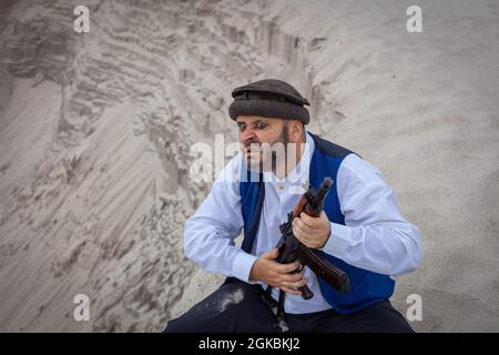 Ein Soldat der Taliban überwacht eine Straße in Afghanistan. Ein Soldat steht mit einer Waffe auf der Wache, um zu töten. Stockfoto