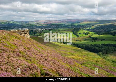 The Worm Stones, ein Grabstein in den Hügeln oberhalb von Glossop am High Peak, Derbyshire, England. Heidekraut blüht auf den Mooren unten. Stockfoto