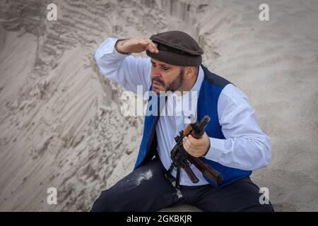 Ein Soldat der Taliban überwacht eine Straße in Afghanistan. Ein Soldat steht mit einer Waffe auf der Wache, um zu töten. Stockfoto