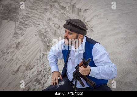 Ein Soldat der Taliban überwacht eine Straße in Afghanistan. Ein Soldat steht mit einer Waffe auf der Wache, um zu töten. Stockfoto