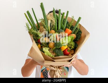 Nahaufnahme einer Frau mit einem Bouquet aus Bio-Gemüse aus eigenem Anbau. Stockfoto