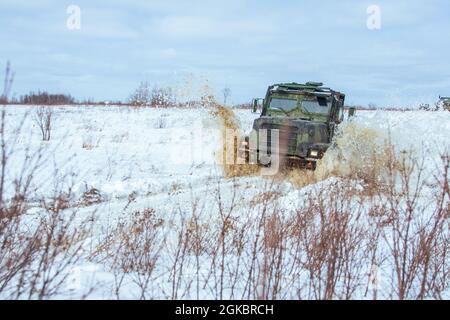 Eine US-Marine fährt einen mitteltaktischen Fahrzeugaustausch durch ein Gefechtsfahrzeug im Gelände der Fortbildungsentwicklung auf Fort Drum, New York, 6. März 2021. Marines of Combat Logistics Bataillon 8 ermöglichte Marines in der 2. Marine Logistics Group das Überleben bei kaltem Wetter und Motortransporte. Stockfoto