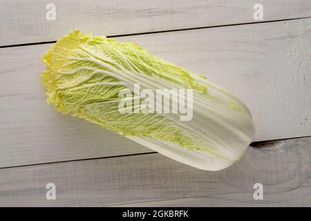 Ein frischer Chinakohl auf einem Holztisch, Nahaufnahme, Draufsicht. Stockfoto