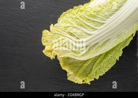 Ein reifer, frischer Chinakohl auf einem Schieferstein, Nahaufnahme, Draufsicht. Stockfoto