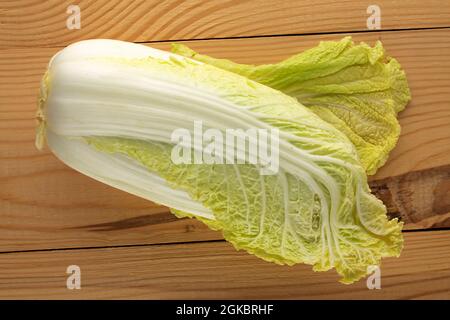 Ein frischer Chinakohl auf einem Holztisch, Nahaufnahme, Draufsicht. Stockfoto